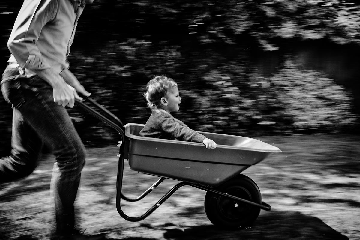 Simon Atkins is a documentary family photographer, photo shows a wheel barrow race